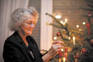 Woman placing ornaments on Christmas tree